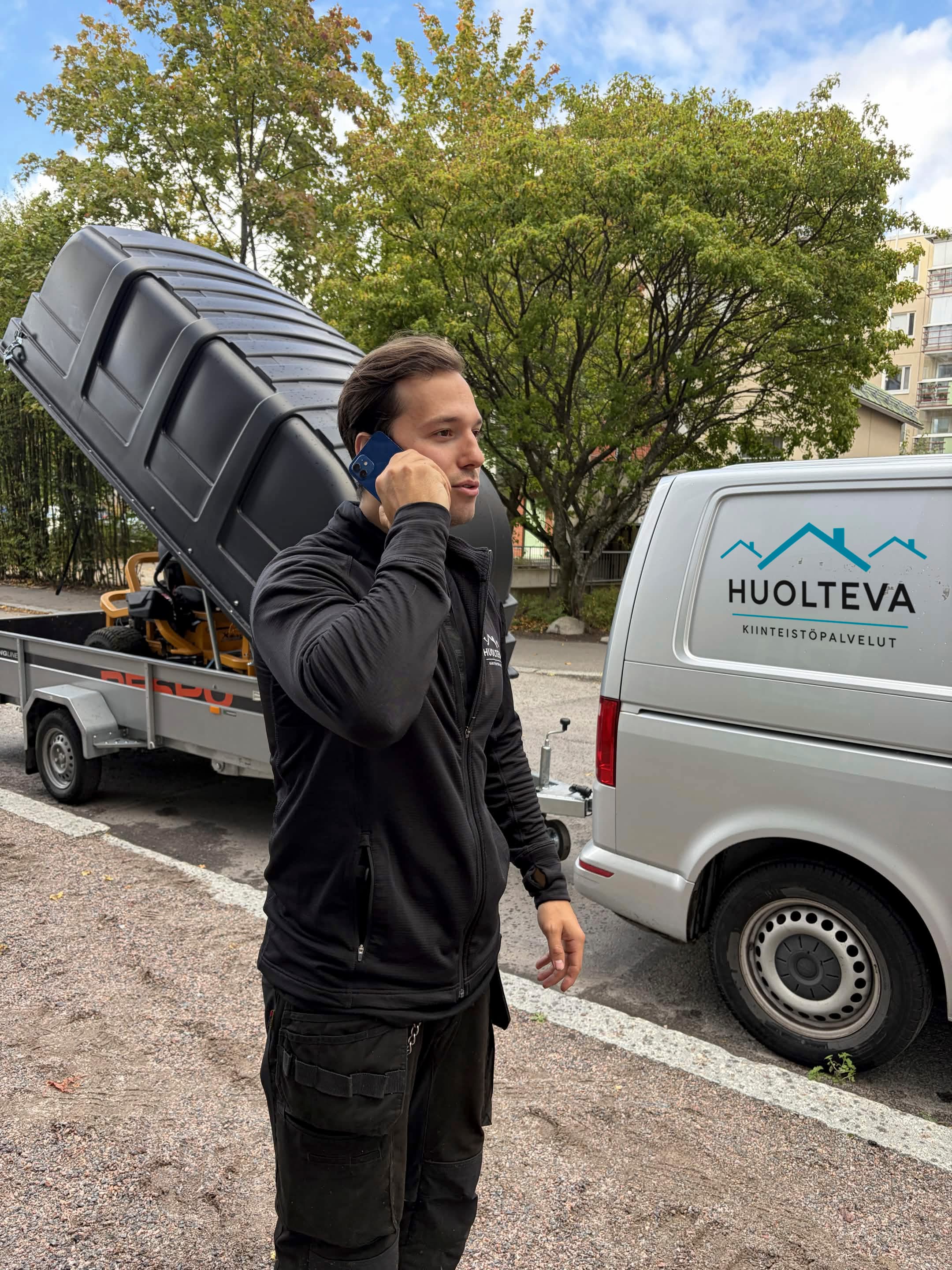 Huoltevan työntekijä puhelimessa auton vieressä